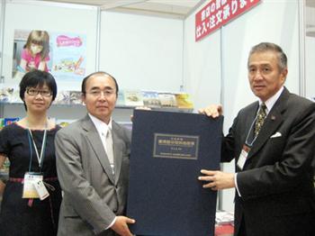 駐日代表馮代表寄台(右)贈本館出版品予拓殖大學國際部長岸澤輝(左)