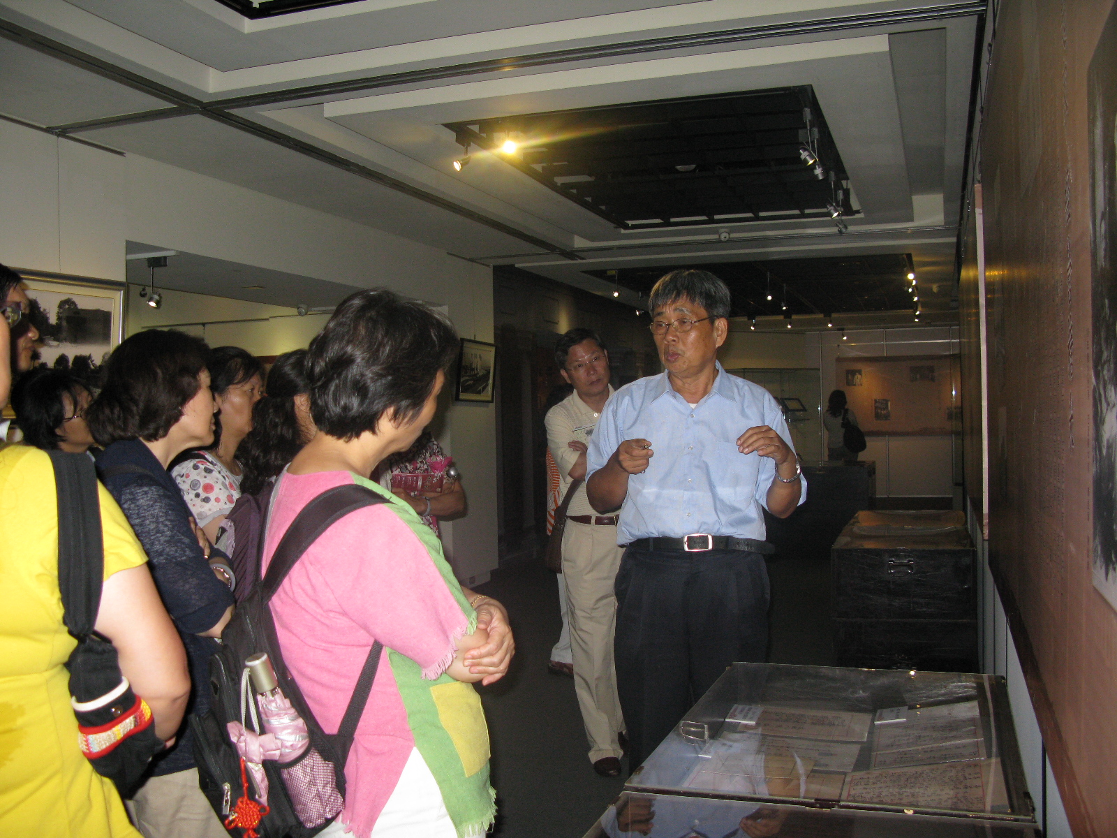 本館林研究員文龍(右1)為參訪者解說臺灣五大家族特展檔案及史料
