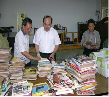本館張館長鴻銘（中）、整理組林組長明洲（右）及孫振明先生（左）檢視多種期刊創刊號