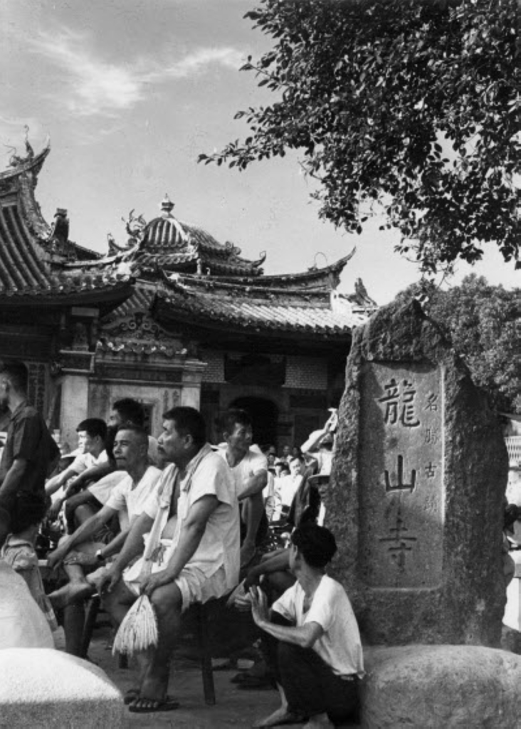 在名勝古蹟龍山寺看戲的人們 (前殿廣場石碑) 1954  / 黃則修攝